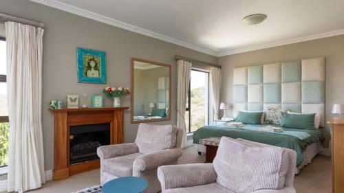 een slaapkamer met een bed, een stoel en een spiegel bij Fly Me To The Moon Guesthouse in Mosselbaai