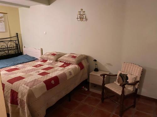 a bedroom with a bed and a chair at Gite Deja Vu in Montcabrier