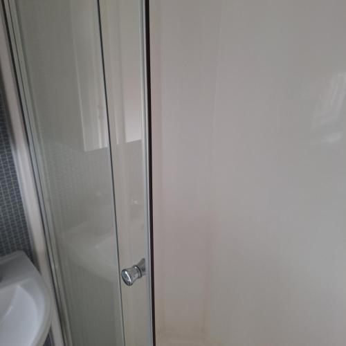 a shower door in a bathroom with a toilet at 11 The Meadoows in Hirn