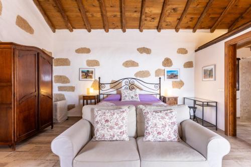 a living room with a bed and a couch at Casa La Tosca in San Miguel de Abona