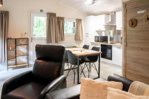 a kitchen and living room with a table and chairs at Chalet Bos en Pootjes in Lanaken