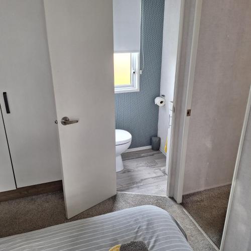 a bathroom with a white toilet and a sink at 11 The Meadoows in Hirn