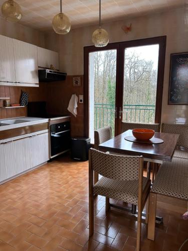 een keuken met een tafel en stoelen en een raam bij CASA D'IRENE Havre de paix cosy romantique proche des châteaux de la Loire et a proximité du Parc de Beauval in Mareuil-sur-Cher