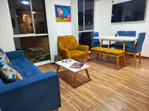 Apartamento Blue House Paipa في بايبا: غرفة معيشة مع أريكة وكراسي وطاولة