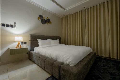 een slaapkamer met een groot bed en een bank bij شقة بطابع انيق بحي الملقا in Riyad