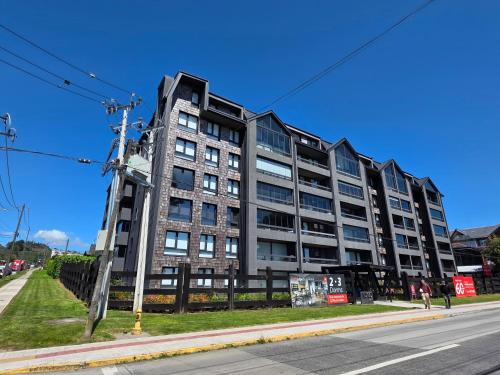 a tall building on the corner of a street at 2D apartment and 2 baths, 4 P, temperate pool in Puerto Varas