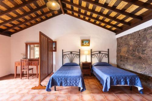 - une chambre avec 2 lits et une table dans l'établissement Casa Rural Vera De La Hoya, à San Miguel de Abona