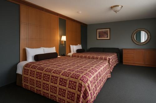 a hotel room with two beds and a mirror at Liberty Inn Absecon Atlantic City in Galloway