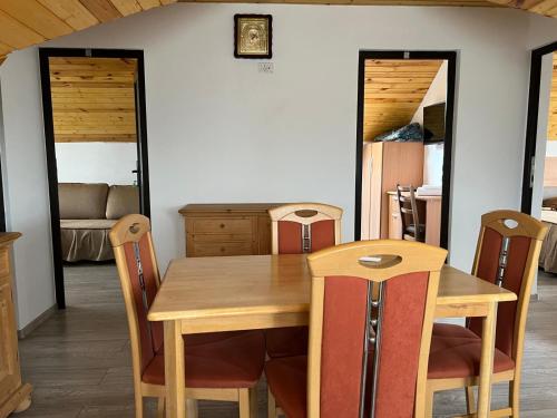 a dining room with a wooden table and chairs at Vila Onyx in Ţibăneşti