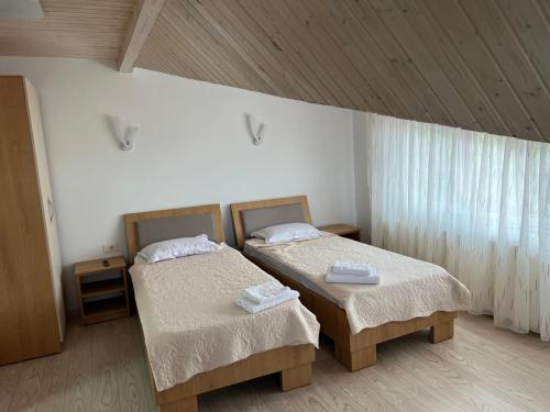 a room with two beds and a window at Vila Onyx in Ţibăneşti