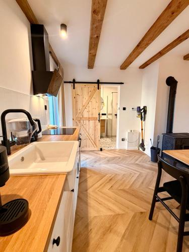 a kitchen with a sink and a wooden floor at Blisko in Kuźnica