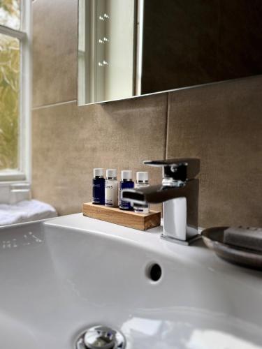 a bathroom counter with a sink with a mirror at Scarborough Hill Country Inn in North Walsham