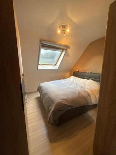 a bedroom with a large bed with a window at Modern Duplex Apartment with terrace view in Stekene