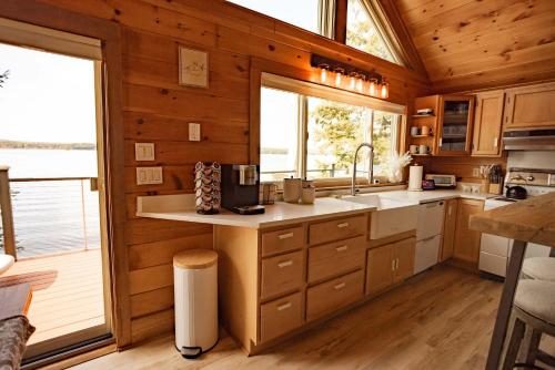a kitchen with wooden walls and a large window at Red Cedar Haven Lakeside Tranquility in Sidney