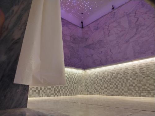 DerouaChambre Aéroport Mohammed 5的浴室墙壁是紫色的，窗帘是白色的。