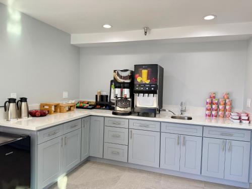 a kitchen with white cabinets and a coffee maker at Royale Inn 老爺客棧 - San Gabriel, Los Angeles in Rosemead