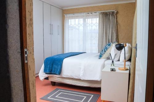 a bedroom with a bed and a window at The Rest in Maseru