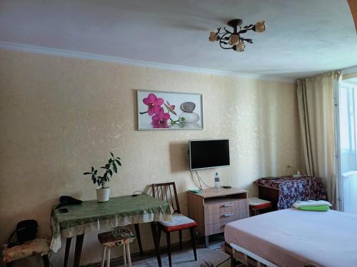 una camera da letto con un letto, una scrivania e una TV di Genius a Chişinău