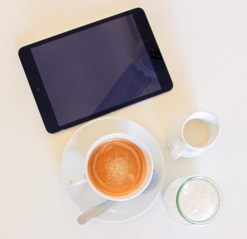 a cup of coffee on a table with a tablet at Nordic Villa in Abuja