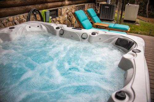 ein Whirlpool mit Stühlen und eine Terrasse in der Unterkunft Ascension Cabin - hot tub, fire pit, babbling brook in Mount Nebo