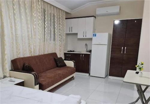 een woonkamer met een bank en een keuken bij Özlem Apart&Pansiyon in Hatay