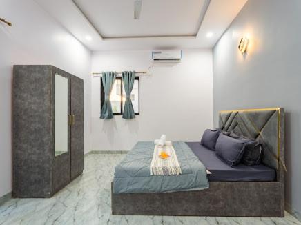 ein Zimmer mit einem Bett mit einem Spiegel und einem Tisch in der Unterkunft Nazar Villa in Malavli