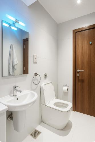 a white bathroom with a toilet and a sink at Magnolia in Rabat