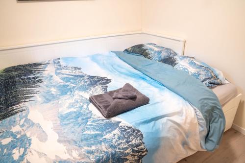 a bed with a picture of the ocean on it at Sakurahuisje in Lanaken