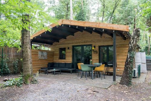 a cabin in the woods with a table and chairs at Sakurahuisje in Lanaken