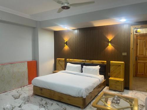 a bedroom with a bed and a table and lights at Nawab's Hotel Balakot in Bālākot