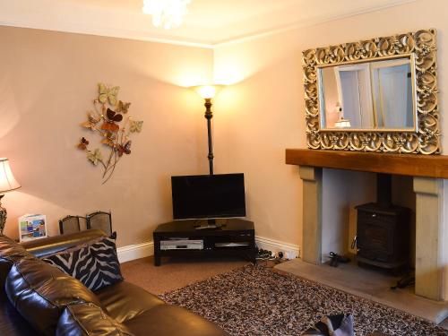 a living room with a couch and a fireplace at Craven House in West Burton