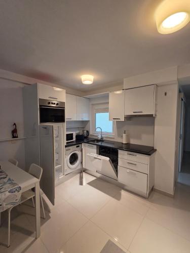 a kitchen with white cabinets and a dishwasher at 2SEA - Apartamento na praia do Ouro - Sesimbra in Sesimbra