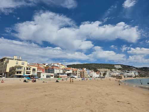 a group of people on a beach with buildings at 2SEA - Apartamento na praia do Ouro - Sesimbra in Sesimbra