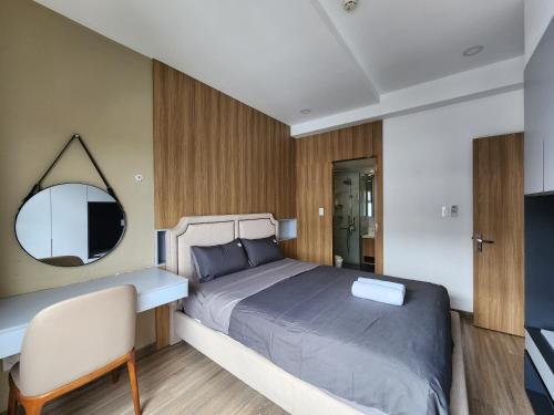 a bedroom with a bed and a mirror and a chair at Elite Apartment - Resort Pool & Gym by Center HCMC in Ho Chi Minh City