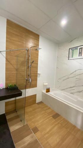 a bathroom with a tub and a glass shower at At My Home in Ban Pha Saeng Lang