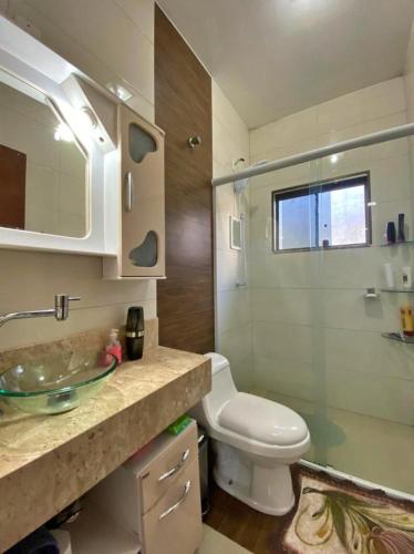 a bathroom with a sink and a toilet and a shower at Casa veraneio 3 quartos com piscina in Xangri-lá