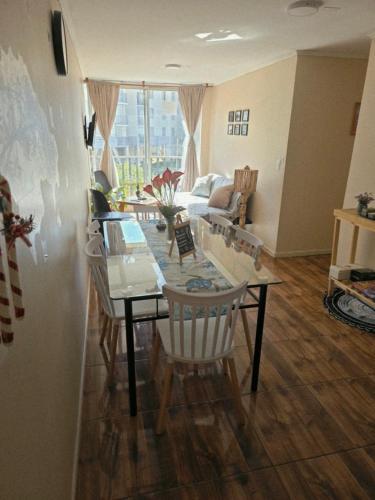 a living room with a dining table and chairs at Departamento Dichato hasta 7 personas frente a la playa in Dichato