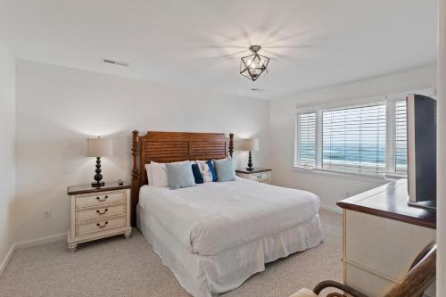 a white bedroom with a bed and a television at SG10C: 10C Seagrove Villa in Isle of Palms