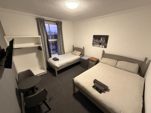 a bedroom with a bed and a desk and a chair at The Woodside in Cowdenbeath