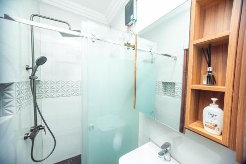 a bathroom with a shower with a glass door at GreyCity Apartments in Accra