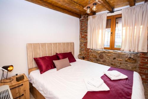 a bedroom with a large white bed with red pillows at Clock Tower Apartments Bitola in Bitola