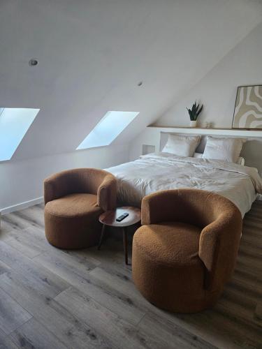 a bedroom with two chairs and a large bed at La suite Cherbourgeoise in Cherbourg en Cotentin