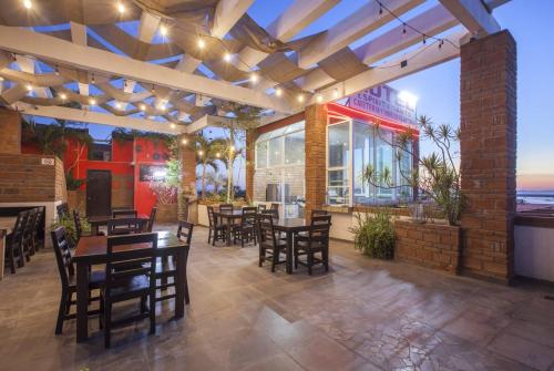 a patio with tables and chairs and a restaurant at Hotel Mágico del Mar in La Paz