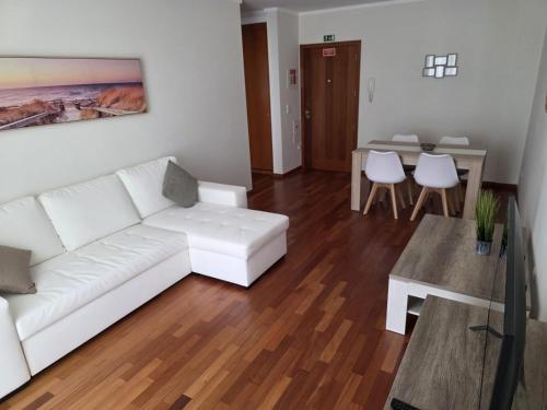 a living room with a white couch and a table at Wings Apartment in Santa Cruz