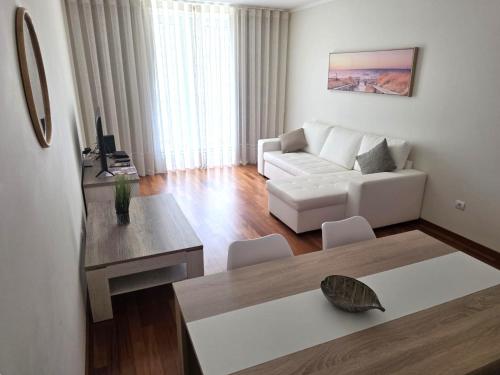 a living room with a white couch and a table at Wings Apartment in Santa Cruz