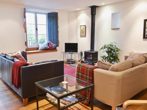 a living room with two couches and a fireplace at Shaplands Barn in Cold Ashton