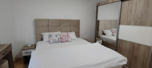 a bedroom with a large white bed and a mirror at Apartman Ciric in Vrnjci