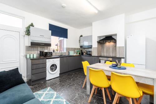 eine Küche und ein Esszimmer mit einem Tisch und gelben Stühlen in der Unterkunft Contractor Friendly 4 Bedroom House in Hemsworth with 6 Beds and Garden in Hemsworth