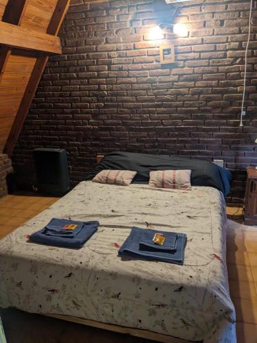a bedroom with a bed with two towels on it at La Alpina in Chivilcoy