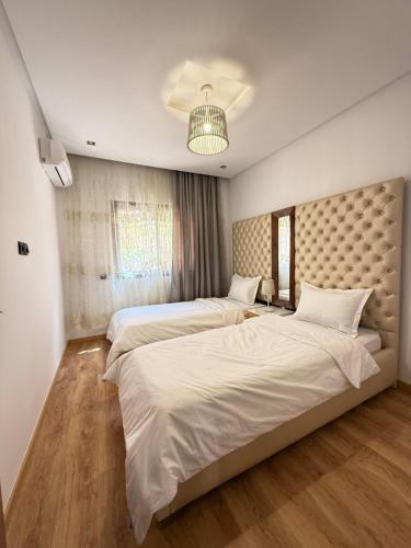 马拉喀什Appartement haut standing的一间卧室配有两张床和床头板